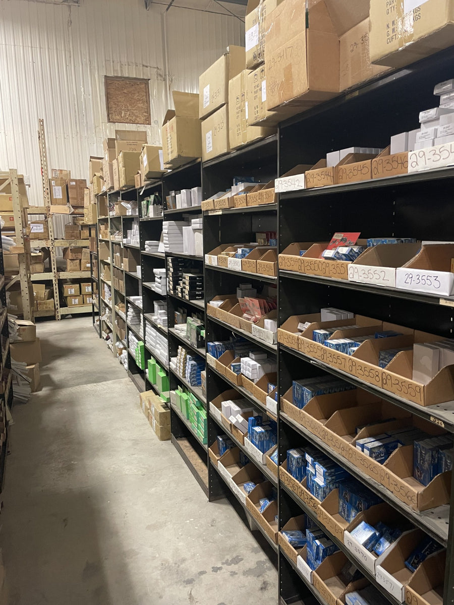 Small motorcycle replacement parts organized in labelled PartsNMore warehouse bins