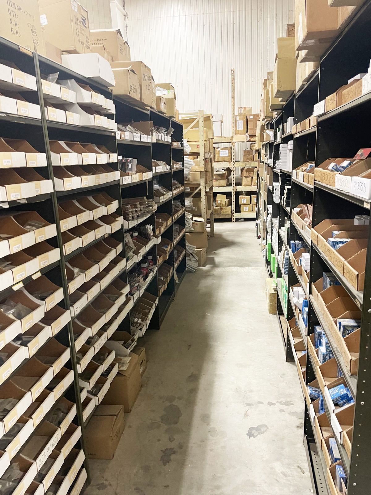 Labelled motorcycle parts bins and boxed stock inside the PartsNMore warehouse